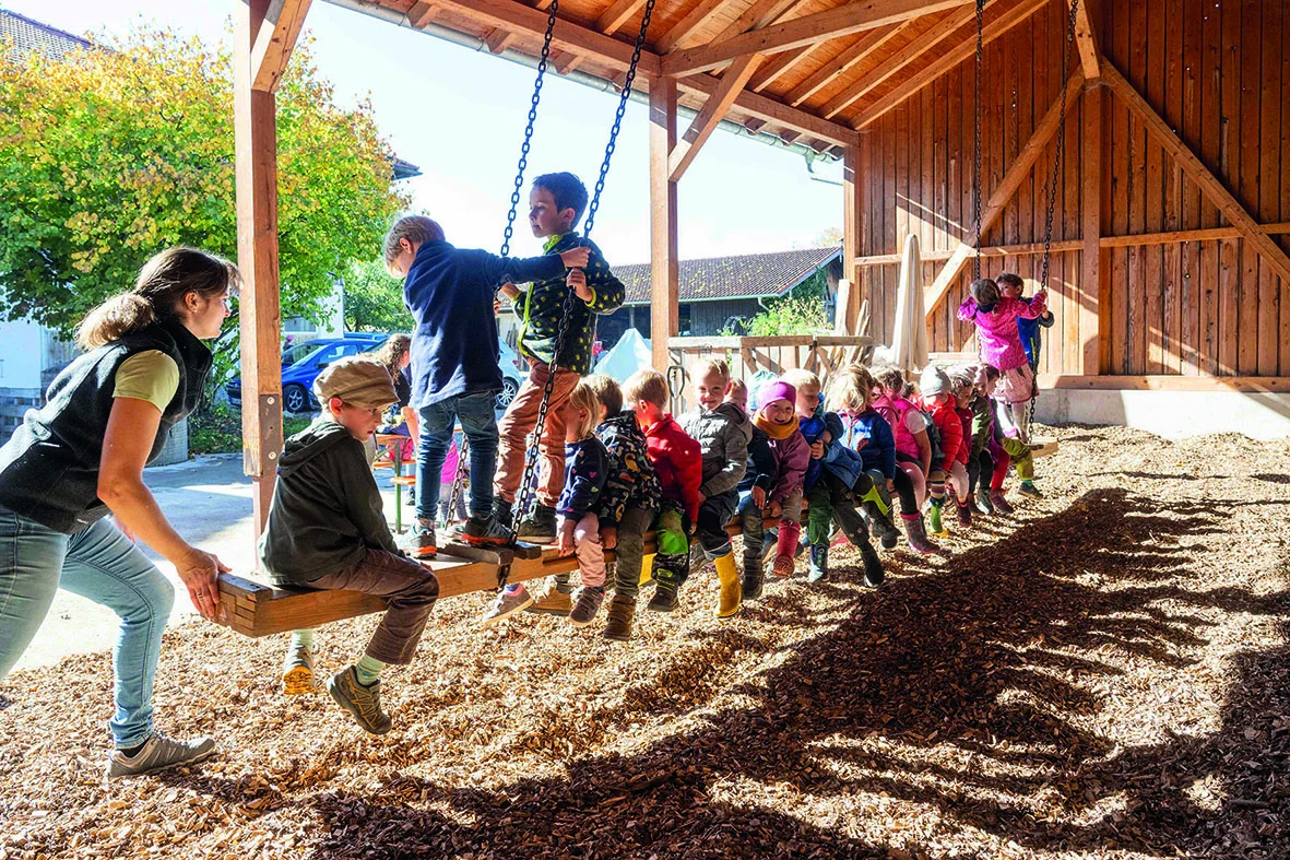 Große Schaukel mit vielen Kindern am Bauernhof